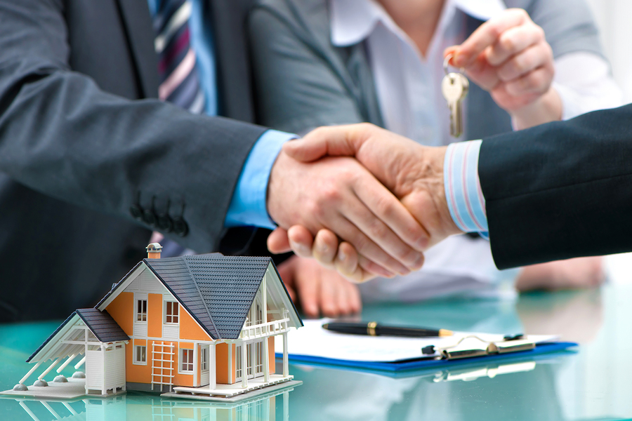 Estate agent shaking hands with customer after contract signatur