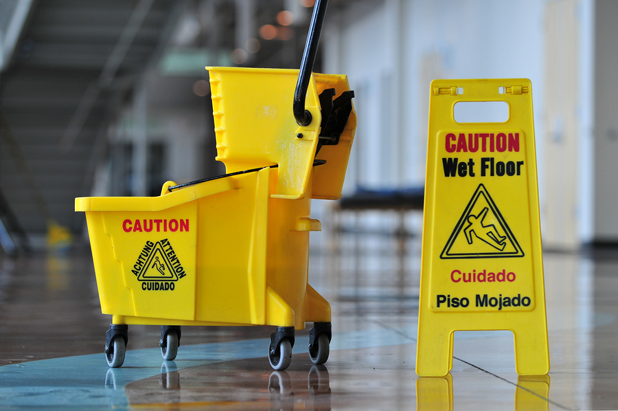 Mop bucket and caution sign inside a building