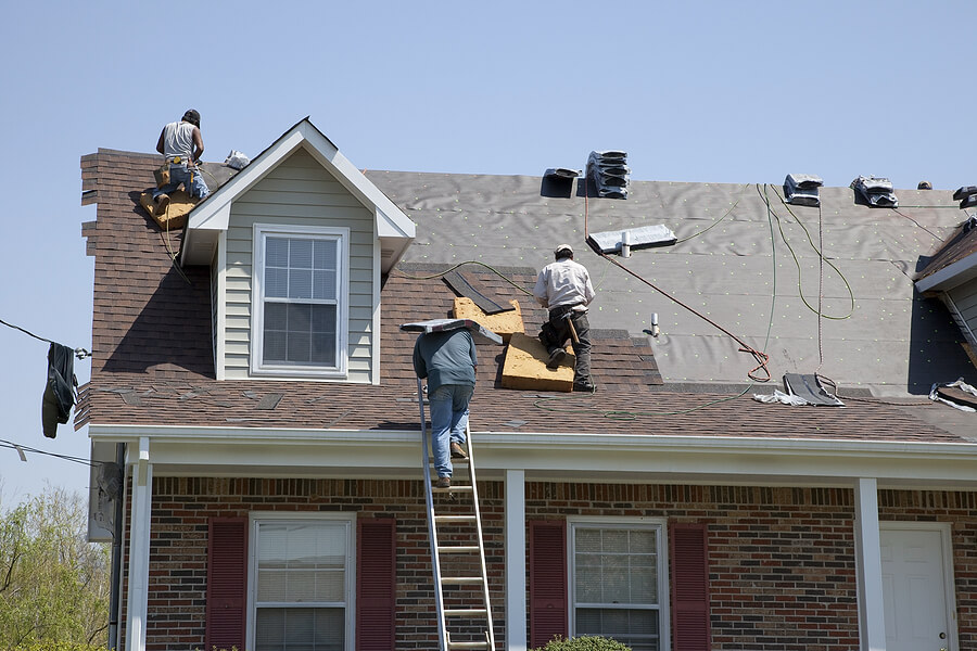 Roofers roofing after settlement with help from an insurance claim lawyer